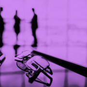 משפקיים ועט על שולחן משרדי ומאחור 3 דמויות מתדיינות