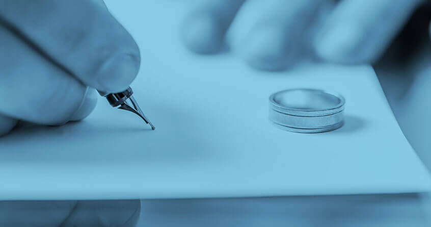 חתימה על ניירת וטבעת מונחת ליד